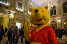 A volunteer is dressing up in Winnie the Pooh costume to