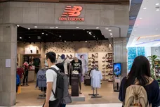 Shoppers walk past the American footwear brand New Balance (