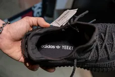 A seller shows off the new Adidas Yeezy Boost 350 shoe model