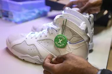 Antonio Gray, 29, of Detroit , places a authentication label on a pair of Jordan 7 retro sneakers after inspecting them the new