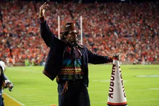 Former Auburn quarterback Cam Newton cheers on his team from the sideline as Auburn Tigers take on Georgia Bulldogs at