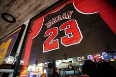 A signed Michael Jordan jersey hangs along with a collection of sports memorabilia.