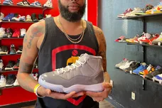 Athens entrepreneur and self-described "sneakerhead" James Dowdy holds an Air Jordan 11 Retro Cool Grey shoe at his business,