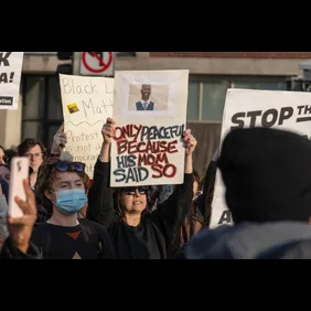 A protester march with a placard that says 'Only Peaceful
