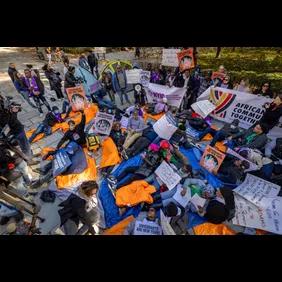 Protesters lay on the ground chanting during a rally and "