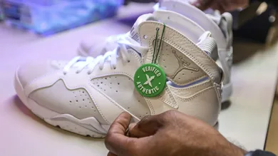 Antonio Gray, 29, of Detroit , places a authentication label on a pair of Jordan 7 retro sneakers after inspecting them the new