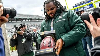 Music artist Tee Grizzley signs a football for a fan during the Michigan State spring game on Saturday, April 16, 2022, at