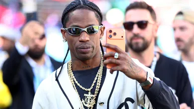 Feb 8, 2026; Santa Clara, CA, USA; Recording artist Travis Scott looks on from the sidelines before Super Bowl LX between the