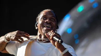 Pusha T holds out some of his jewelry to the crowd as he performs on the Coachella stage during the Coachella Valley Music and