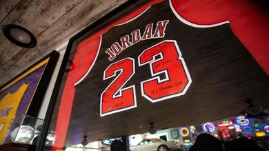 A signed Michael Jordan jersey hangs along with a collection of sports memorabilia.