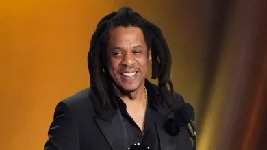 Jay-Z , left, accepts the Dr. Dre Global Impact Award with his daughter Blue Ivy on stage.