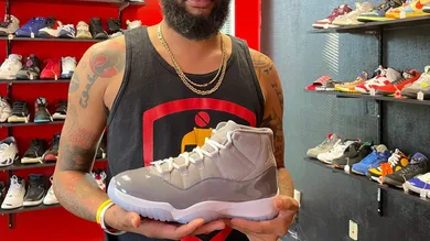 Athens entrepreneur and self-described "sneakerhead" James Dowdy holds an Air Jordan 11 Retro Cool Grey shoe at his business,