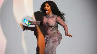 SZA runs to accept her Grammy award for best R&amp;B Song.