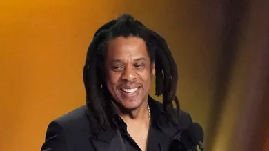 Jay-Z , left, accepts the Dr. Dre Global Impact Award with his daughter Blue Ivy on stage.