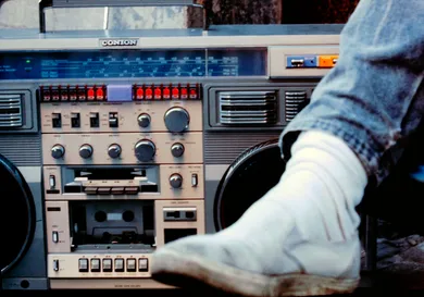 Close up of a male leg next to a large boom box