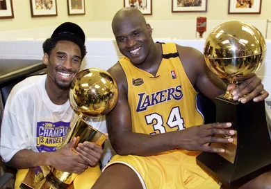 Kobe Bryant (L) of the Los Angeles Lakers holds th