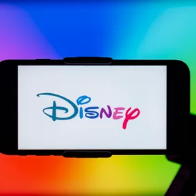 In this photo illustration, Disney logo is seen displayed on